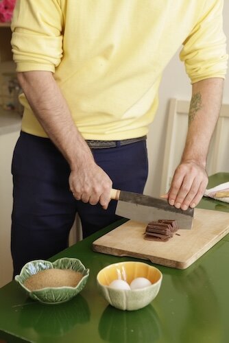 Mann schneidet mit Messer Schokolade