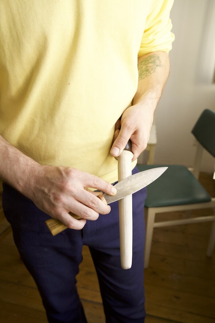 Mann wetzt Messer mit Keramikwetzstab