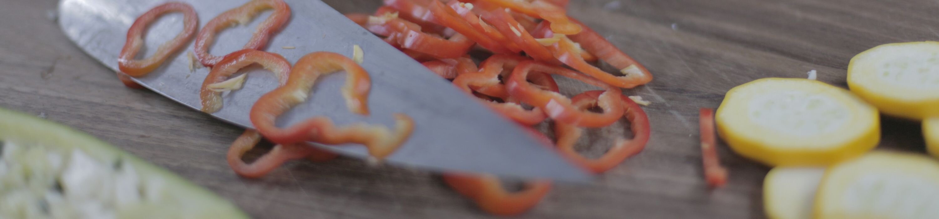 Messerklinge mit dünn geschnittenem Paprika und Gemüse