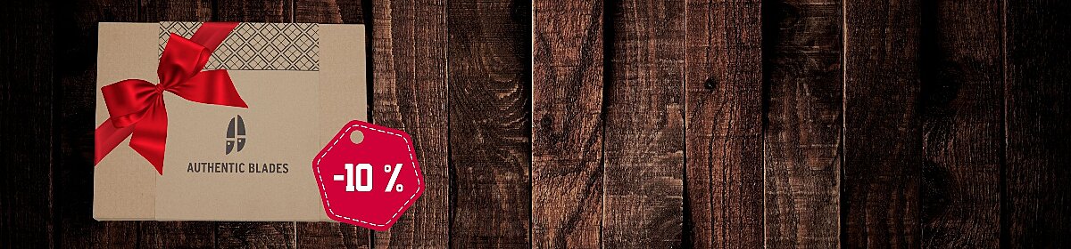 Geschenkpackung AUTHENTIC Blades Messerset mit roter Schleife auf dunklem Holzuntergrund