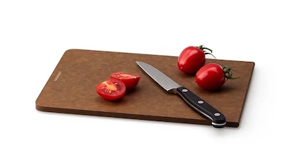 Schneidebrett aus Holzverbundstoff, auf dem Messer und Tomaten liegen
